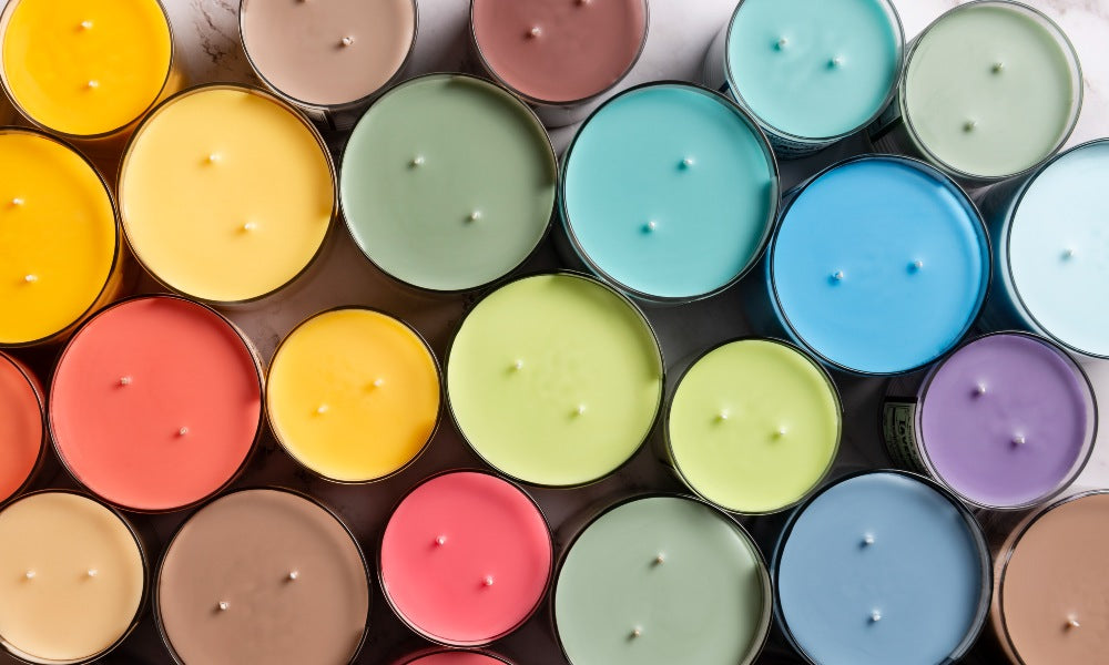 Overhead image of various multi-wick scented candles in various colors of the rainbow.