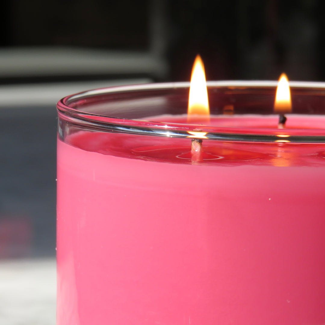 Image of a bright pink colored, multi-wick autumn scented candle 