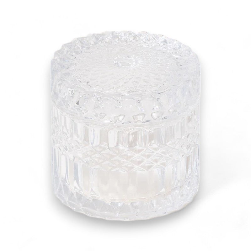 Clear vintage crystal candle jar against a white background