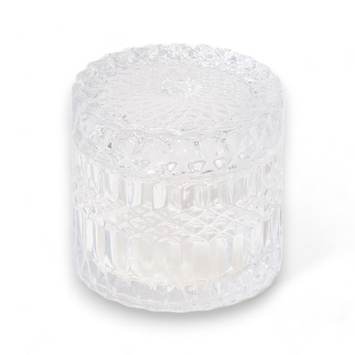 Clear vintage crystal candle jar against a white background