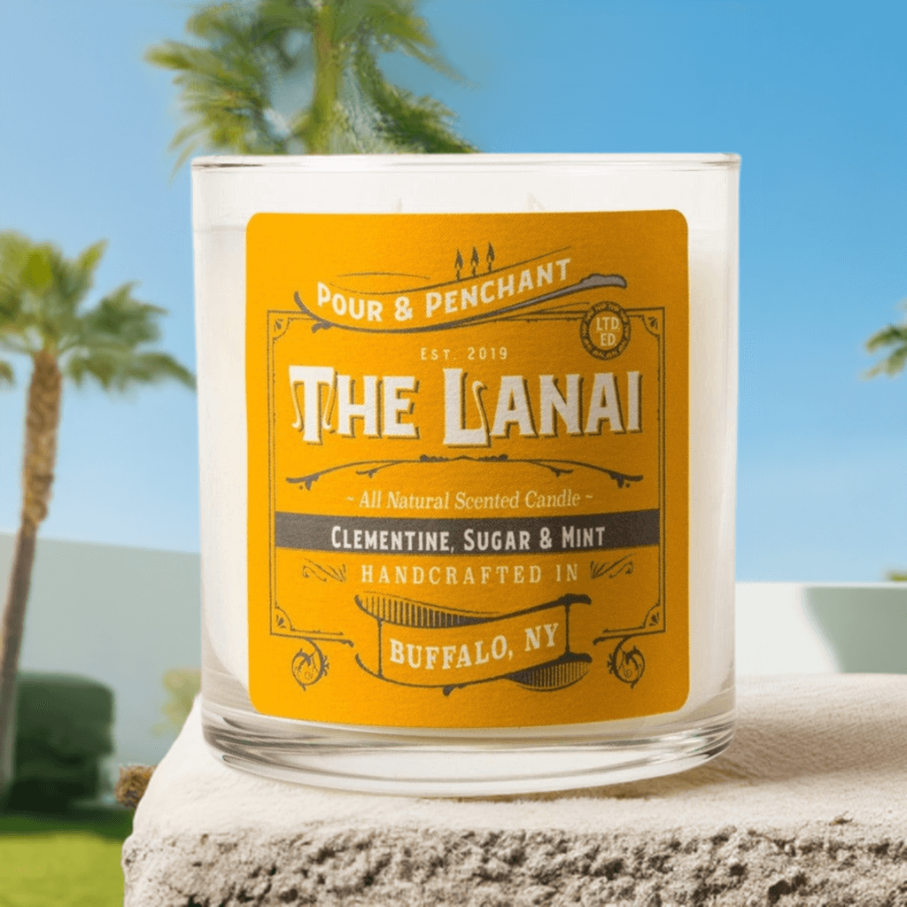 Pour & Penchant 10 oz LANAI candle on a stone patio outside with blue skies and green palm trees